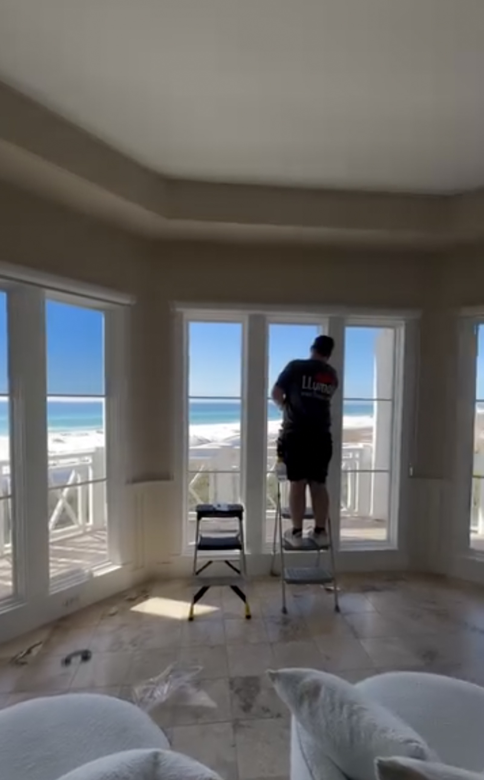 Exzact installer fitting film to Gulf-front windows