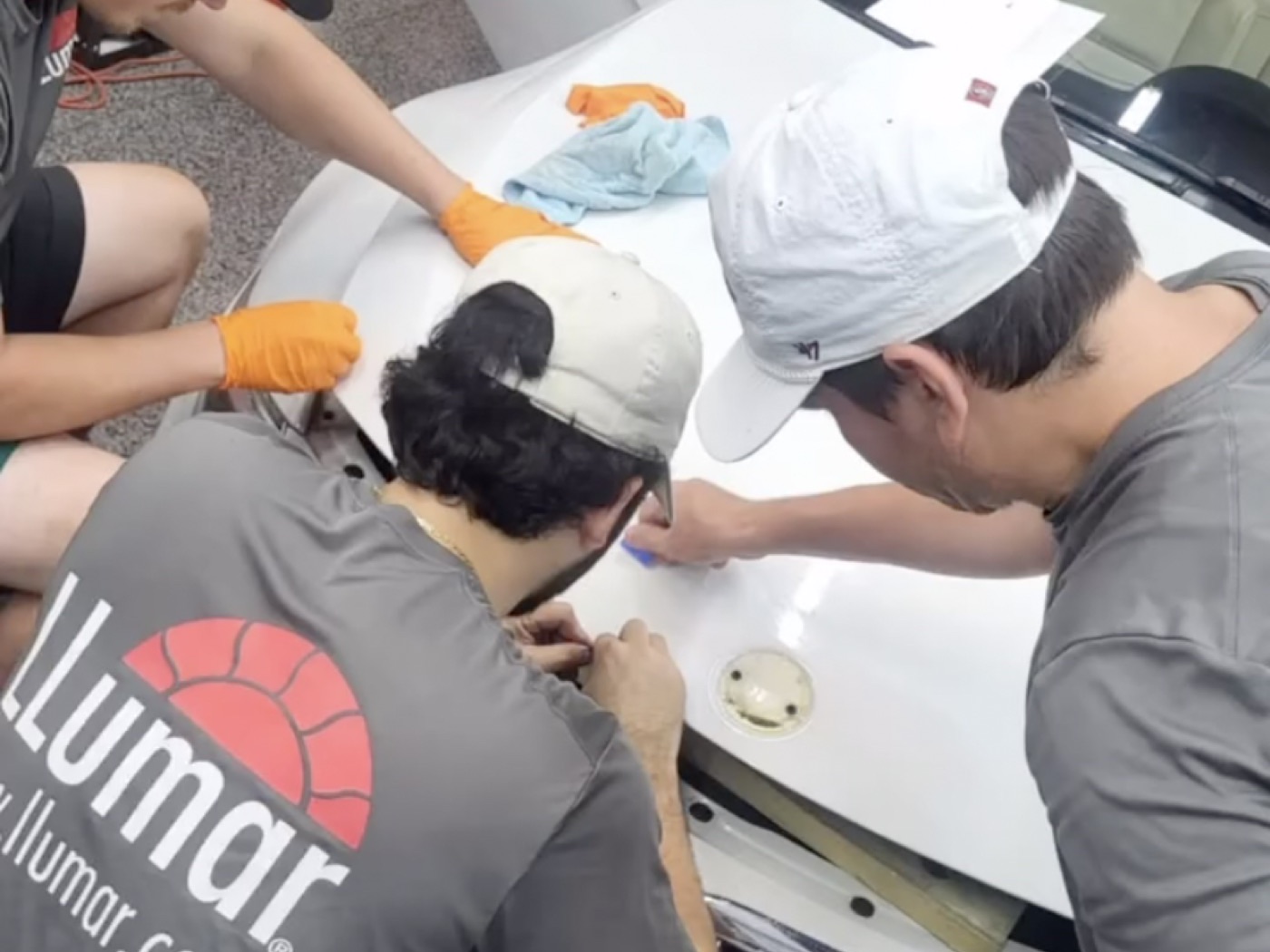 Exzact installers fitting paint protection film to a hood in the Panama City Beach shop